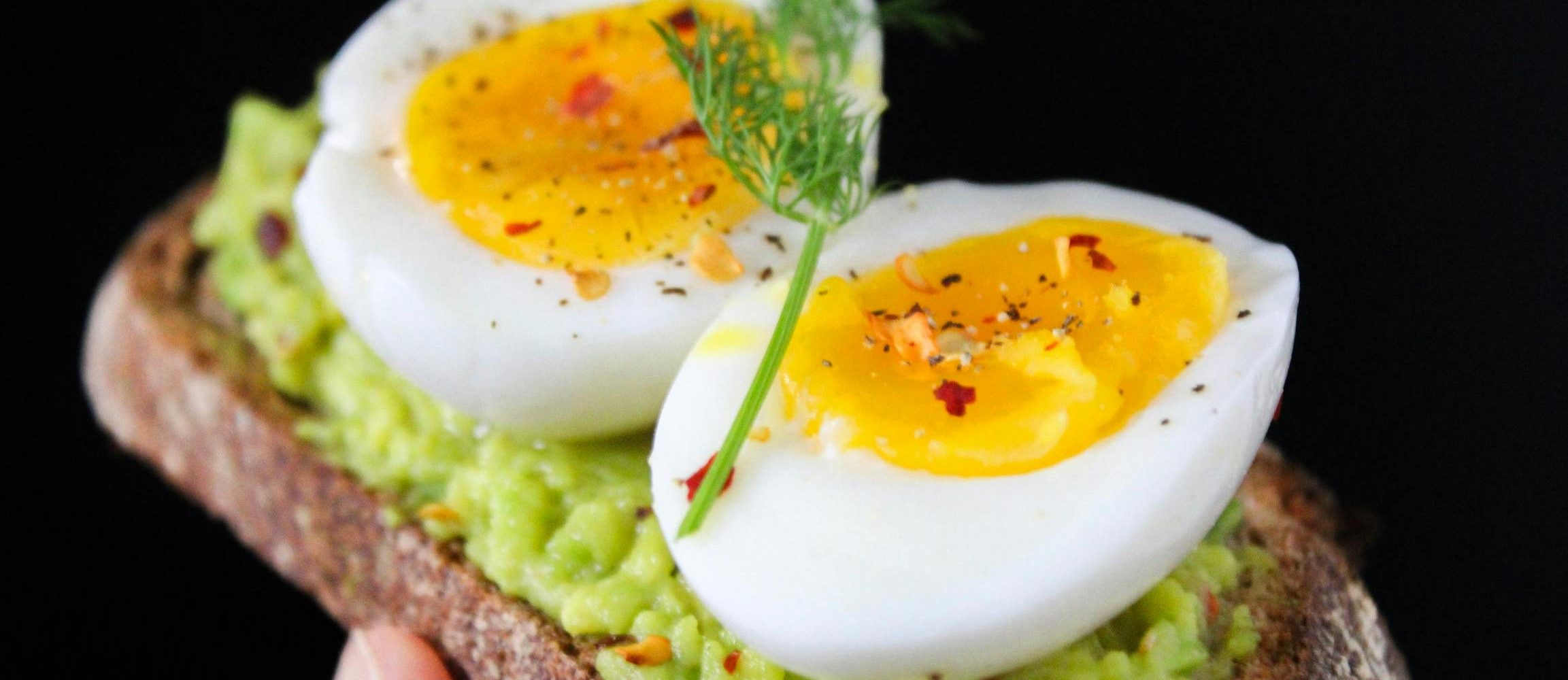 A delicious and healthy avocado toast topped with soft-boiled eggs, perfect for a nutritious breakfast.